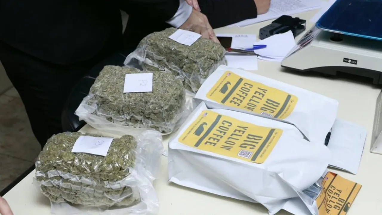Paquetes de café abiertos junto a bloques de marihuana envasados al vacío sobre una mesa de pesaje judicial.