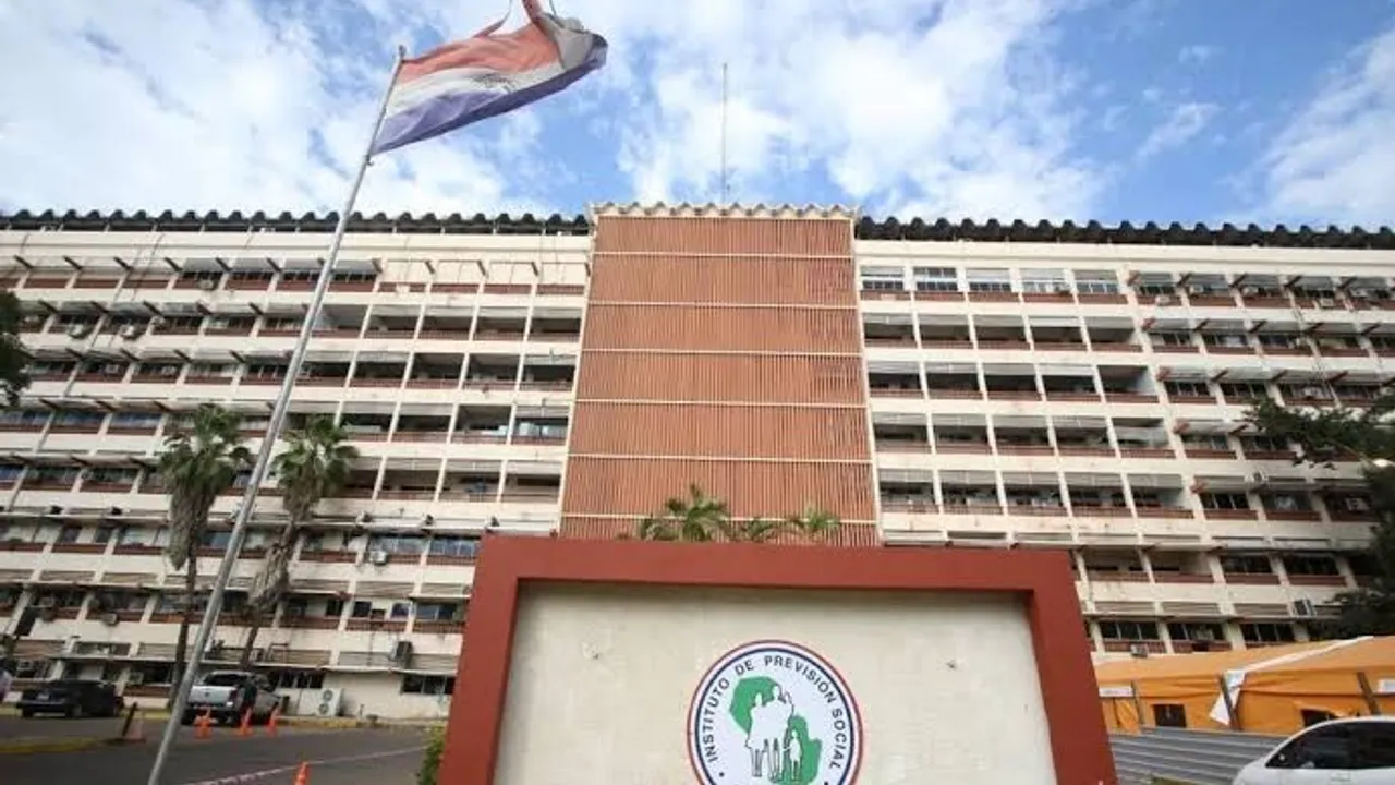 Fachada del Hospital Central del Instituto de Previsión Social con su letrero y la bandera paraguaya.