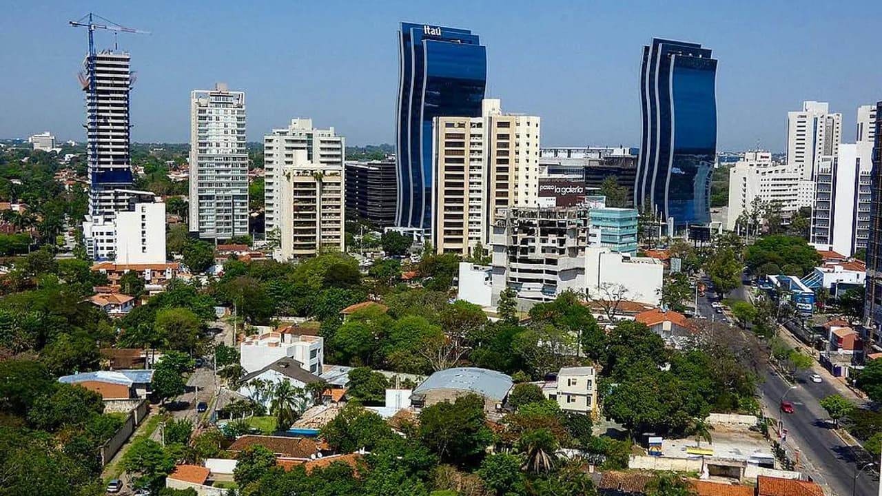 Vista aérea de edificios y torres corporativas entre árboles en una avenida moderna de la ciudad