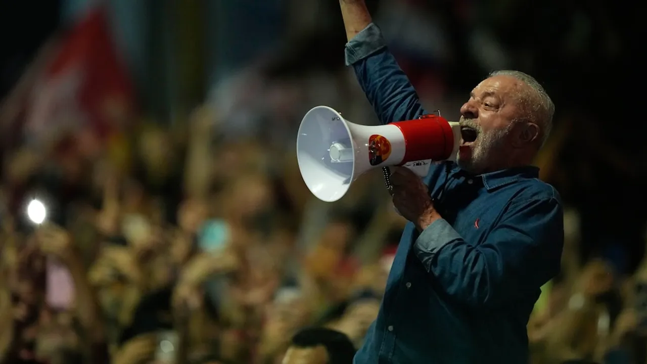 Lula da Silva sostiene un megáfono rojo y blanco con el brazo en alto ante una multitud durante un acto político en Brasil.