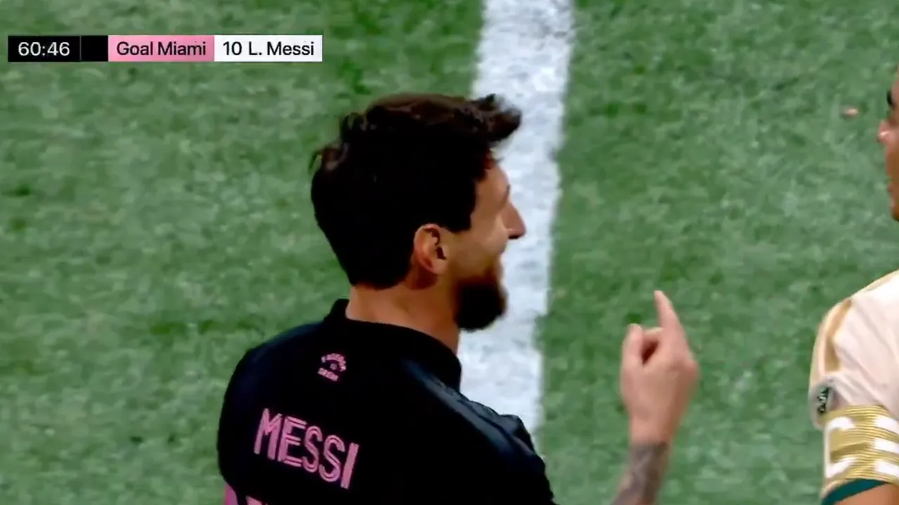 Lionel Messi sonríe y levanta el dedo índice frente al defensor Junior Alonso durante un partido de fútbol.