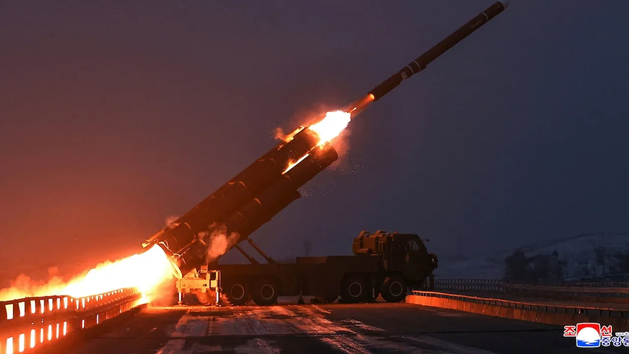 Misil de gran tamaño despegando con una estela de fuego y humo desde un camión lanzador militar durante la noche.