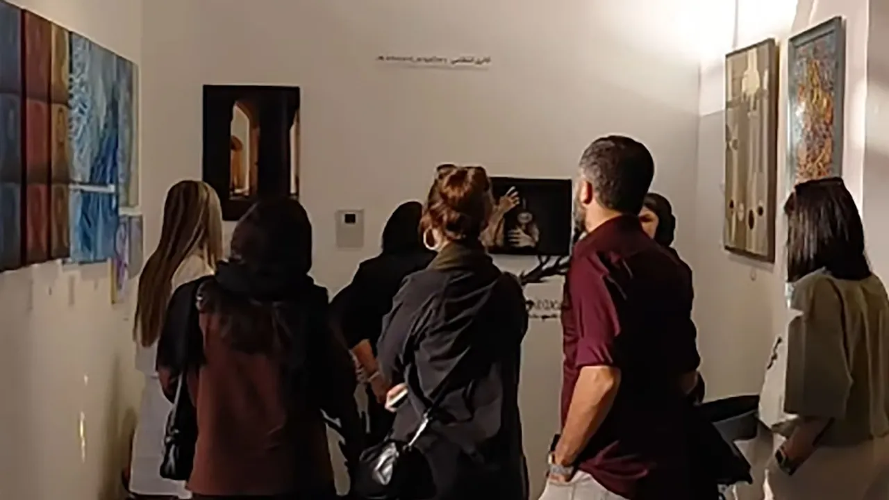 Personas de espaldas observan pinturas expuestas en una galería de arte con paredes blancas y cuadros iluminados.