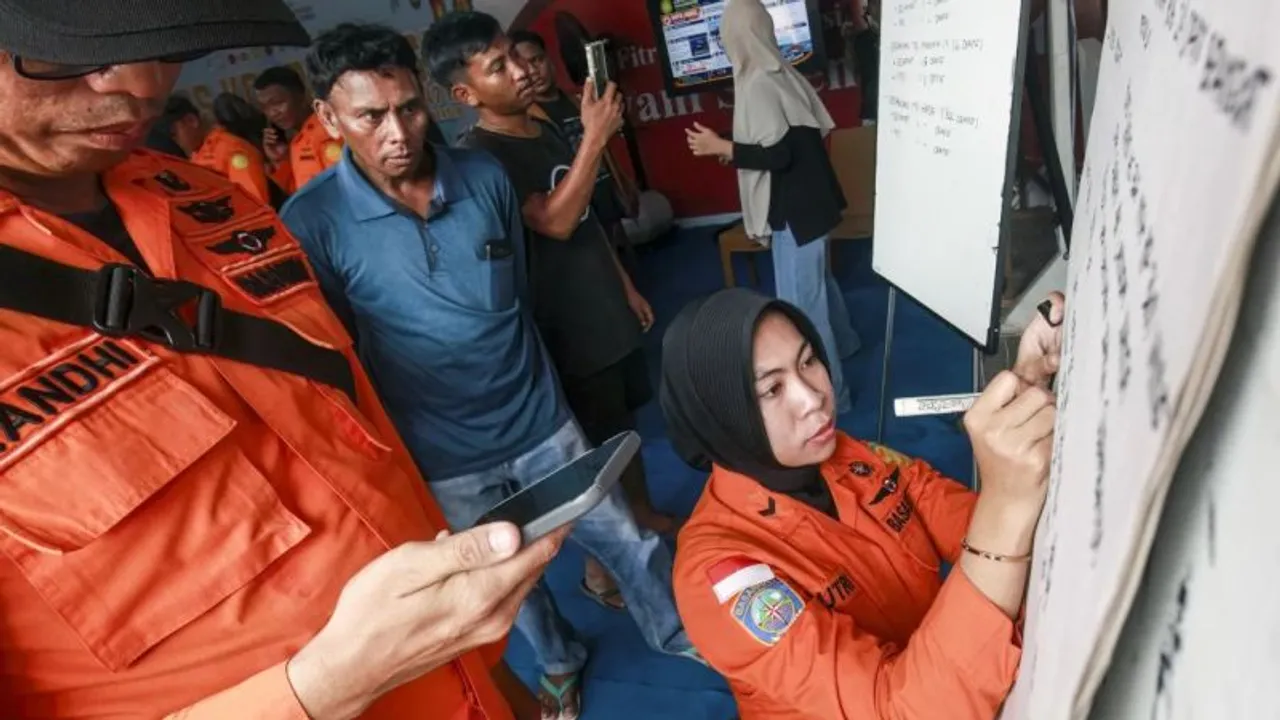 Rescatistas con uniforme naranja anotan datos en una pizarra mientras varias personas observan con atención.