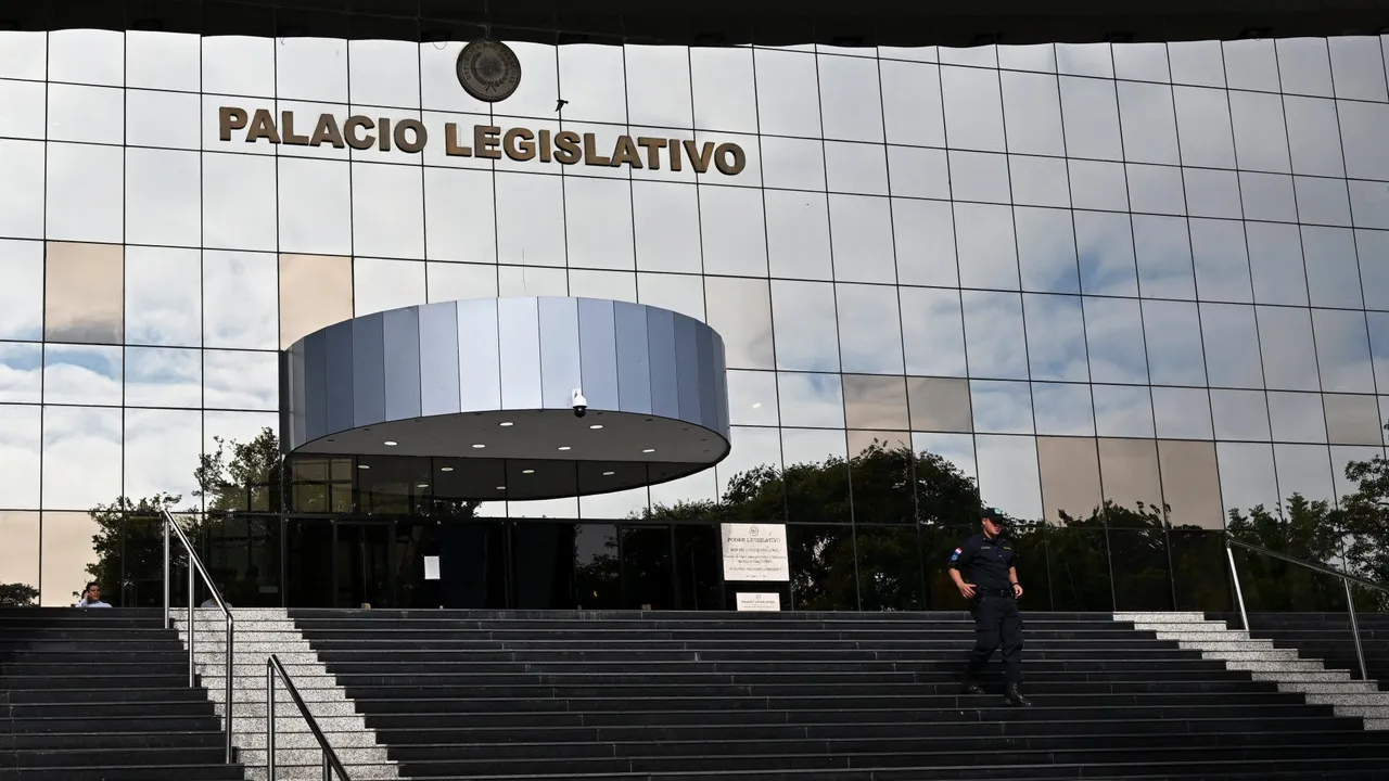 Fachada de vidrio del Palacio Legislativo con escalinatas y un agente policial descendiendo en Asunción.
