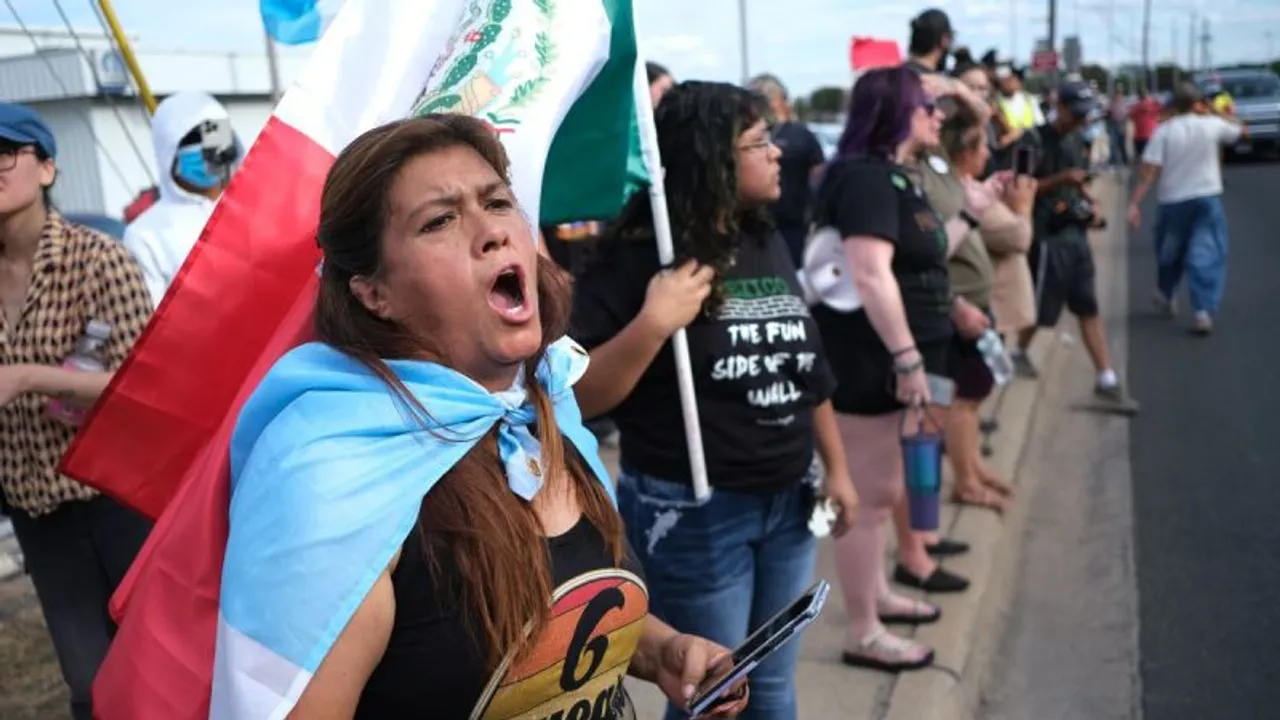 Manifestantes protestan en una calle sosteniendo banderas de México y Guatemala mientras una mujer alza su voz.