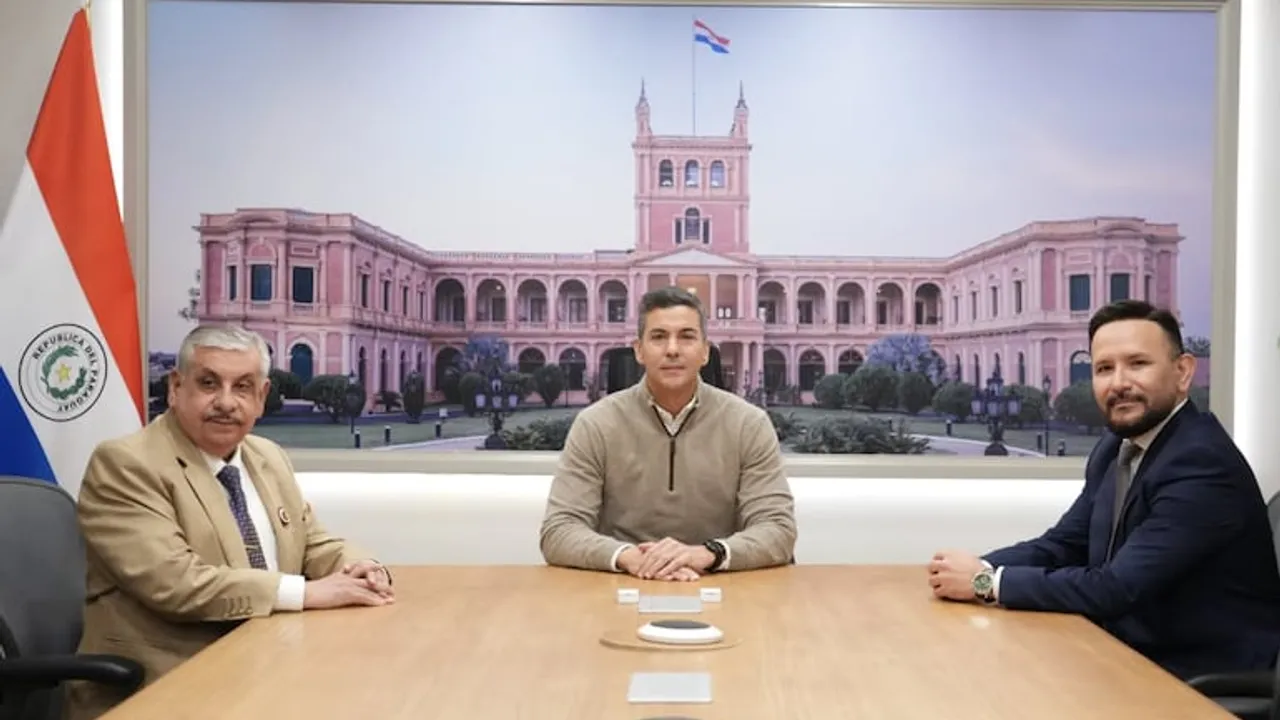 Santiago Peña sentado en una mesa junto a Isaías Fretes y Derlis León, con el Palacio de López al fondo.