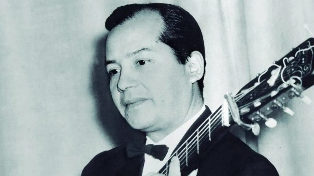 Retrato en blanco y negro de Demetrio Ortiz con traje formal y corbatín, sosteniendo el mástil de una guitarra.