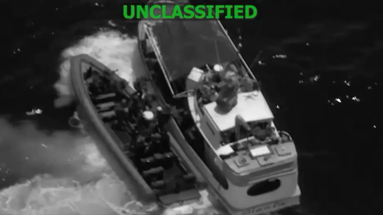 Vista aérea nocturna de una lancha táctica abordando a otra embarcación en el mar con la inscripción unclassified.