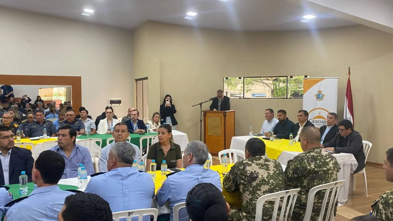 Reunión de autoridades policiales, militares y religiosas en un salón municipal para coordinar actividades públicas.