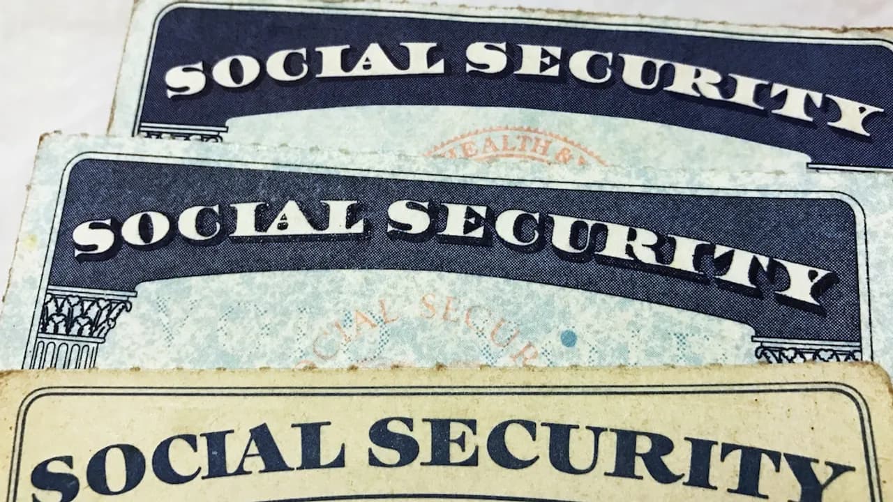 Primer plano de tres tarjetas impresas del Seguro Social de los Estados Unidos apiladas en diagonal.
