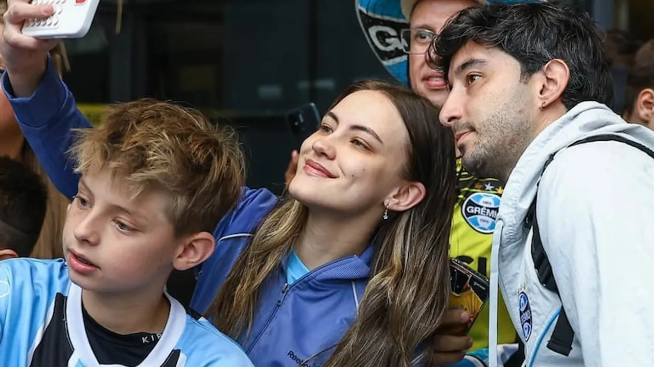 Mathías Villasanti se toma una selfi junto a dos jóvenes aficionados con indumentaria del club Gremio.