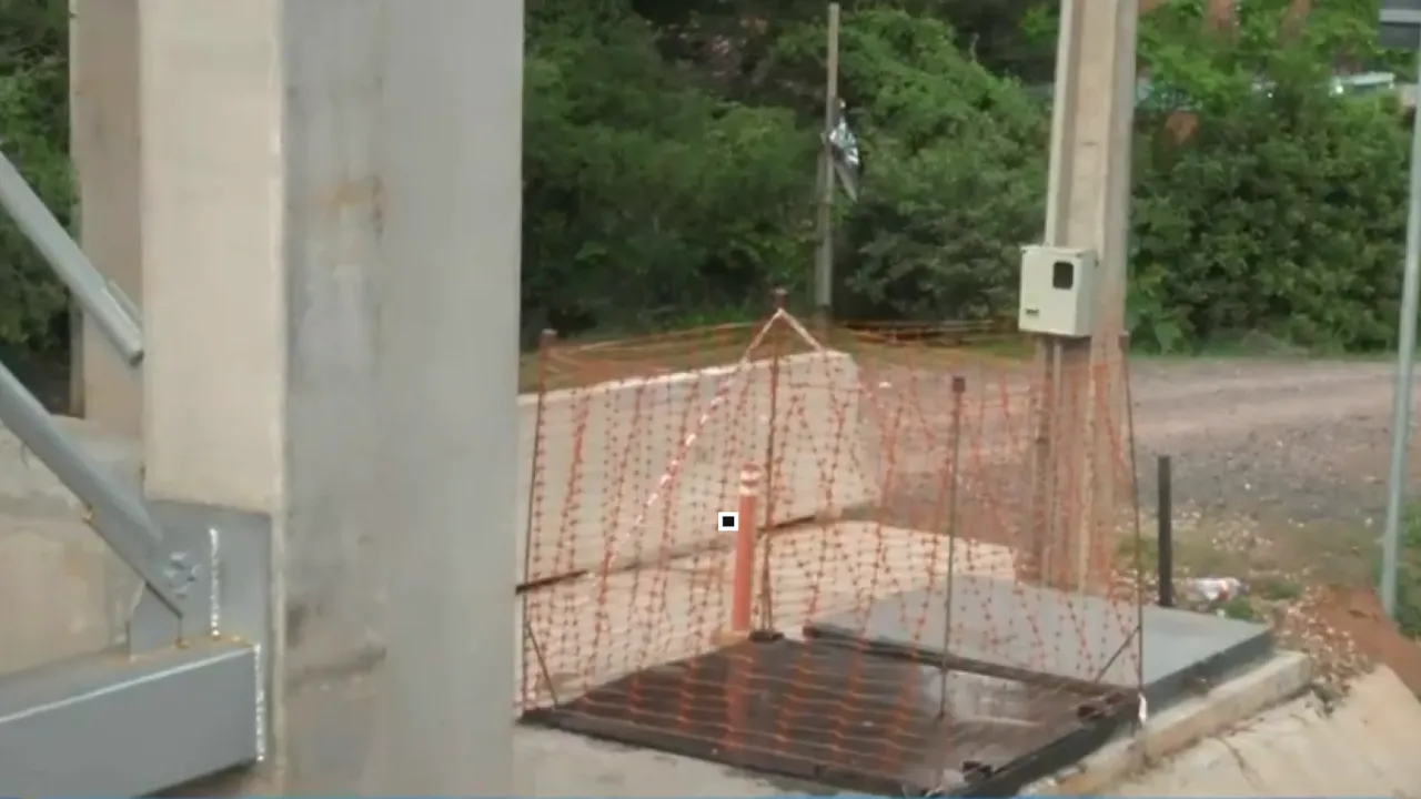 Estructura metálica y base de hormigón cercada con malla naranja donde estaban montados los ascensores peatonales.