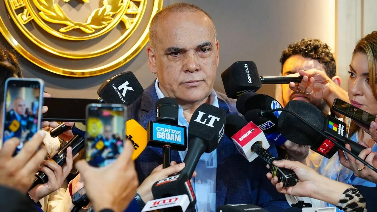 Basilio Núñez responde a periodistas con micrófonos y grabadoras durante una conferencia de prensa en el Congreso.