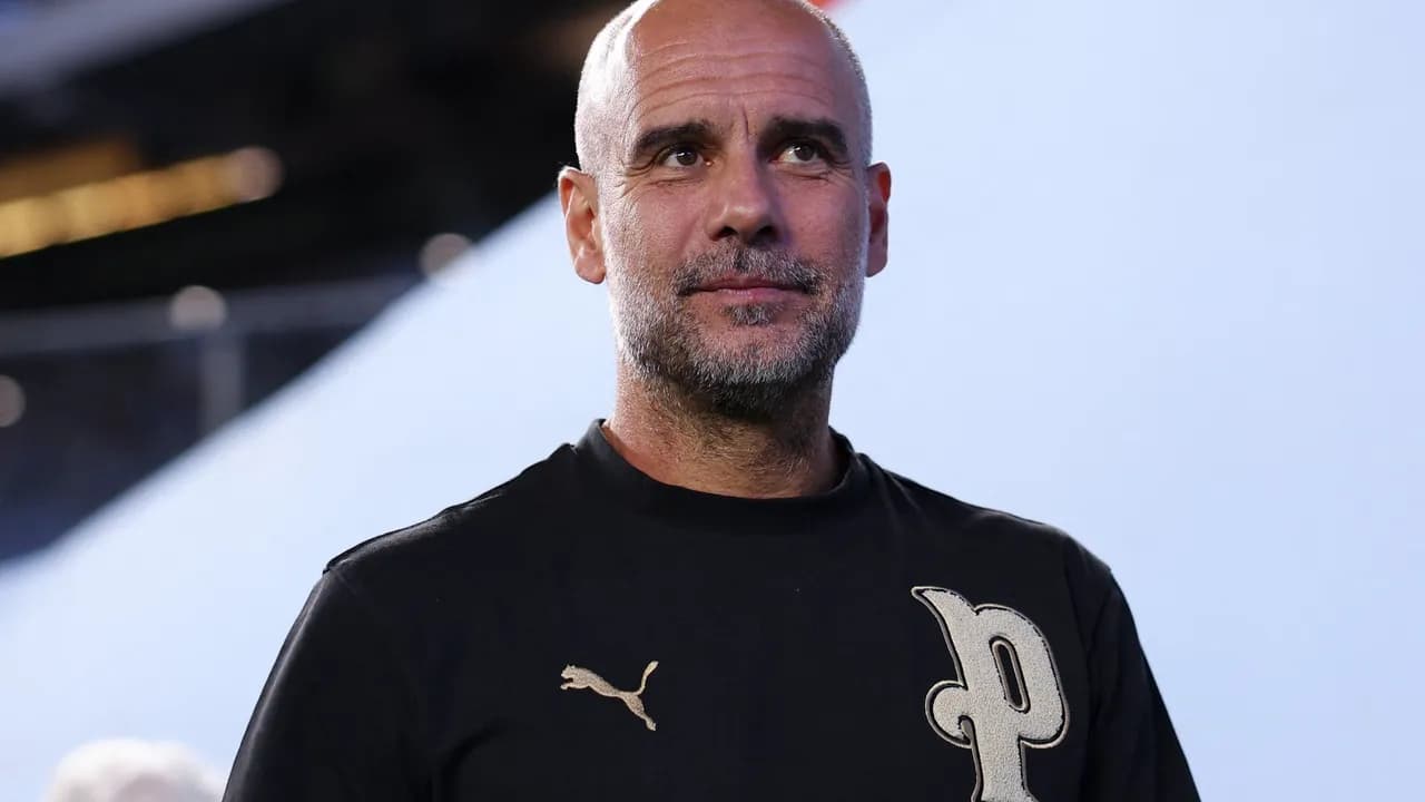 Primer plano del entrenador de fútbol Pep Guardiola vestido con una remera negra y mirando fijamente hacia el frente.