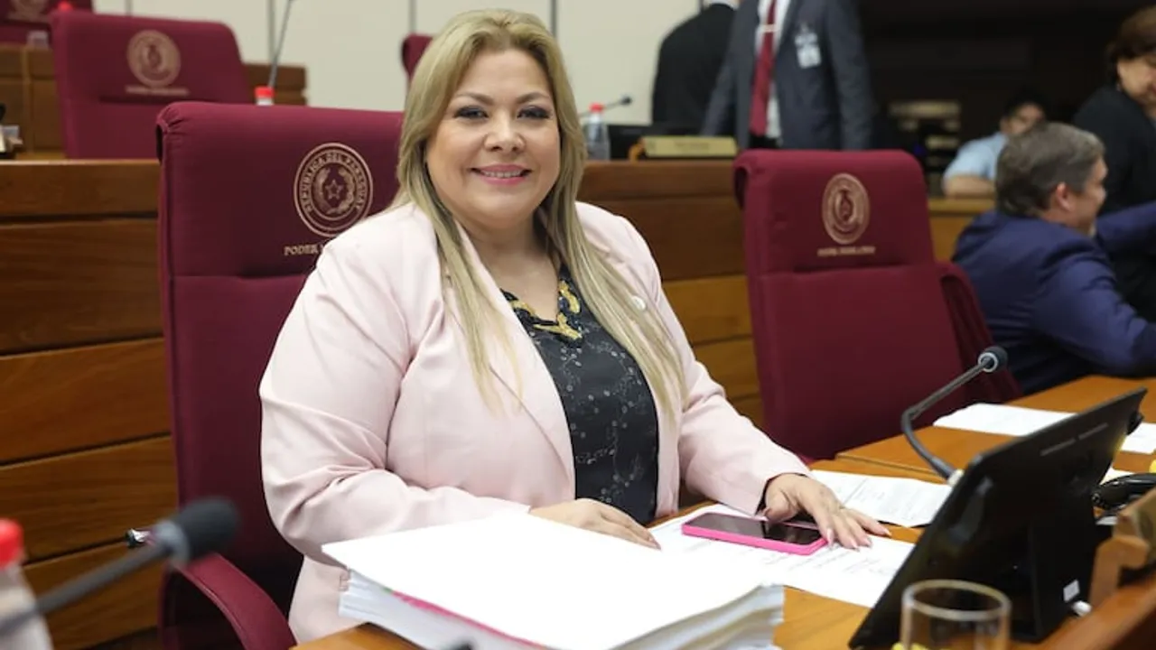 La senadora Zenaida Delgado sonríe sentada en su banca de la Cámara de Senadores de Paraguay.