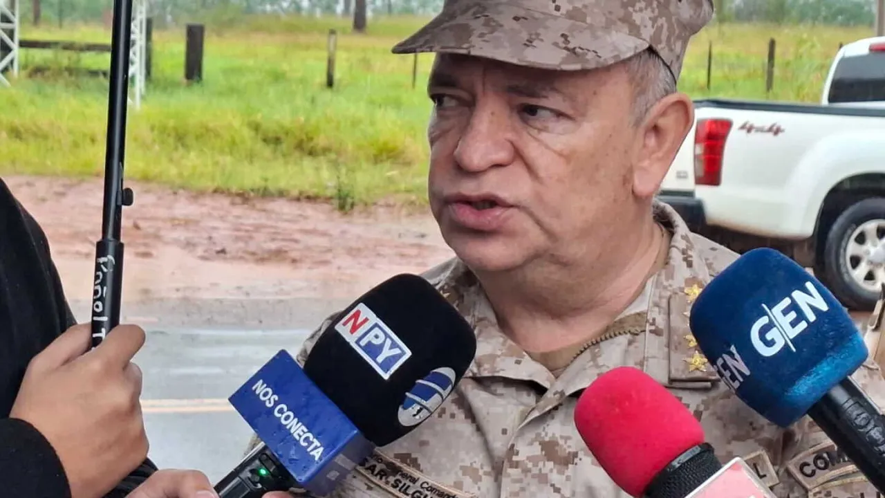 César Silguero con uniforme camuflado y quepis habla ante micrófonos de medios de prensa.