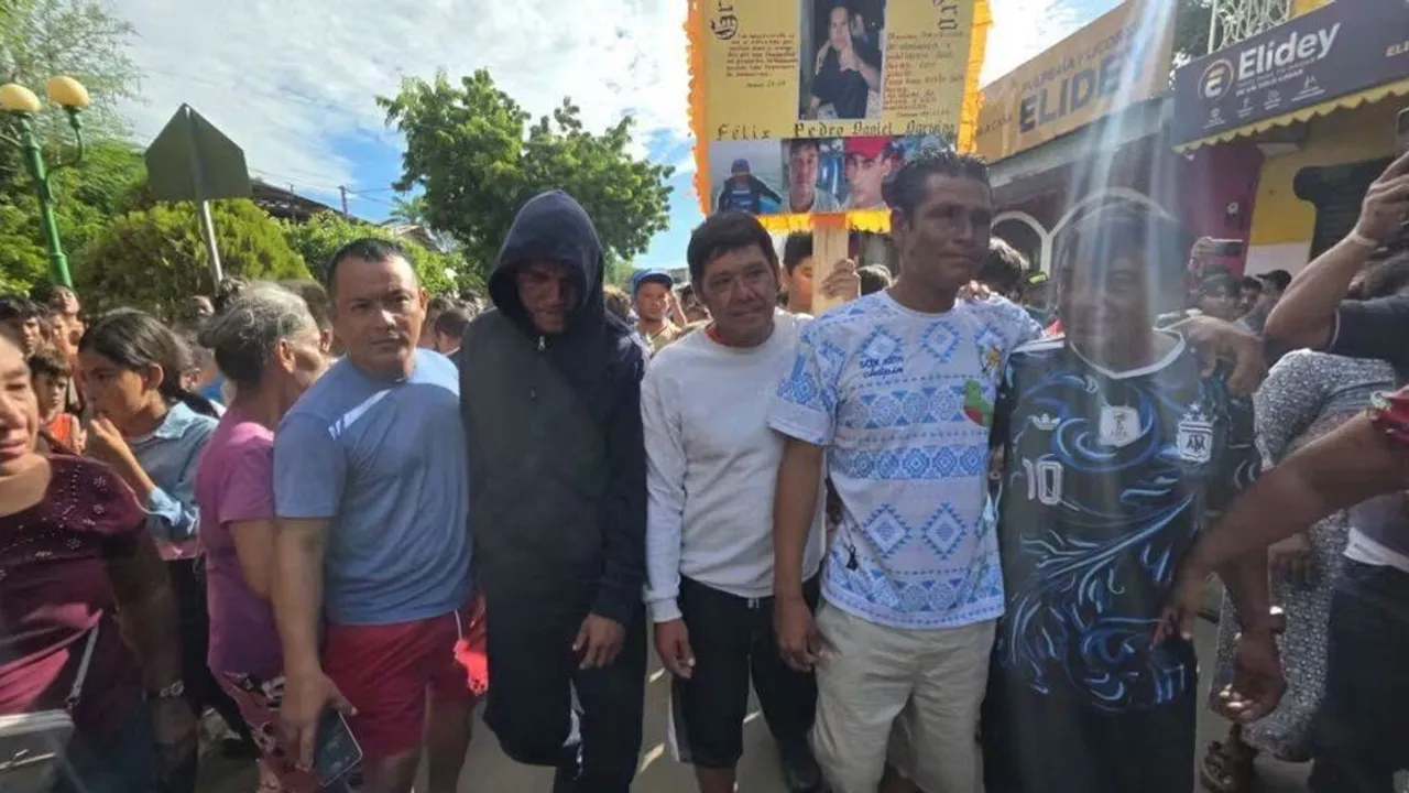 Pescadores rescatados caminan rodeados de vecinos y familiares mientras una persona sostiene un cartel con sus fotos.