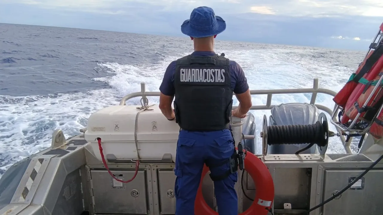 Oficial de guardacostas de espaldas navegando en aguas abiertas durante un operativo de patrullaje marítimo.