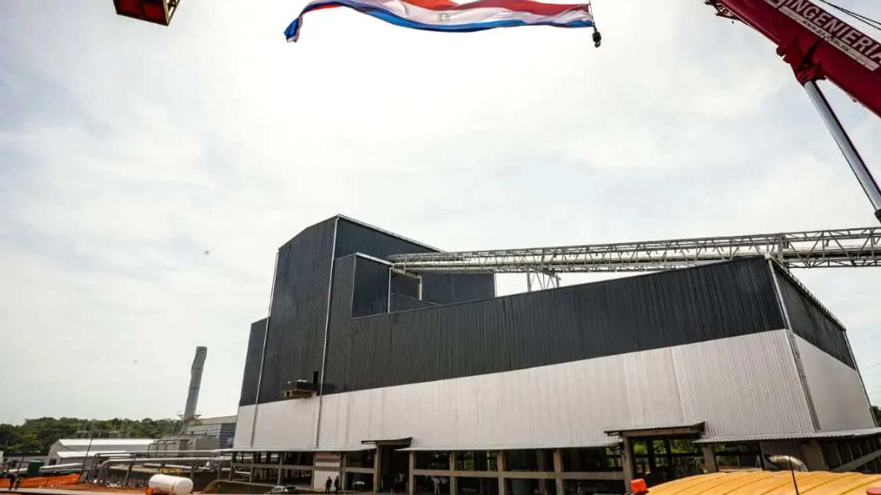 Estructura exterior de una nave industrial metálica con la bandera paraguaya flameando en lo alto.