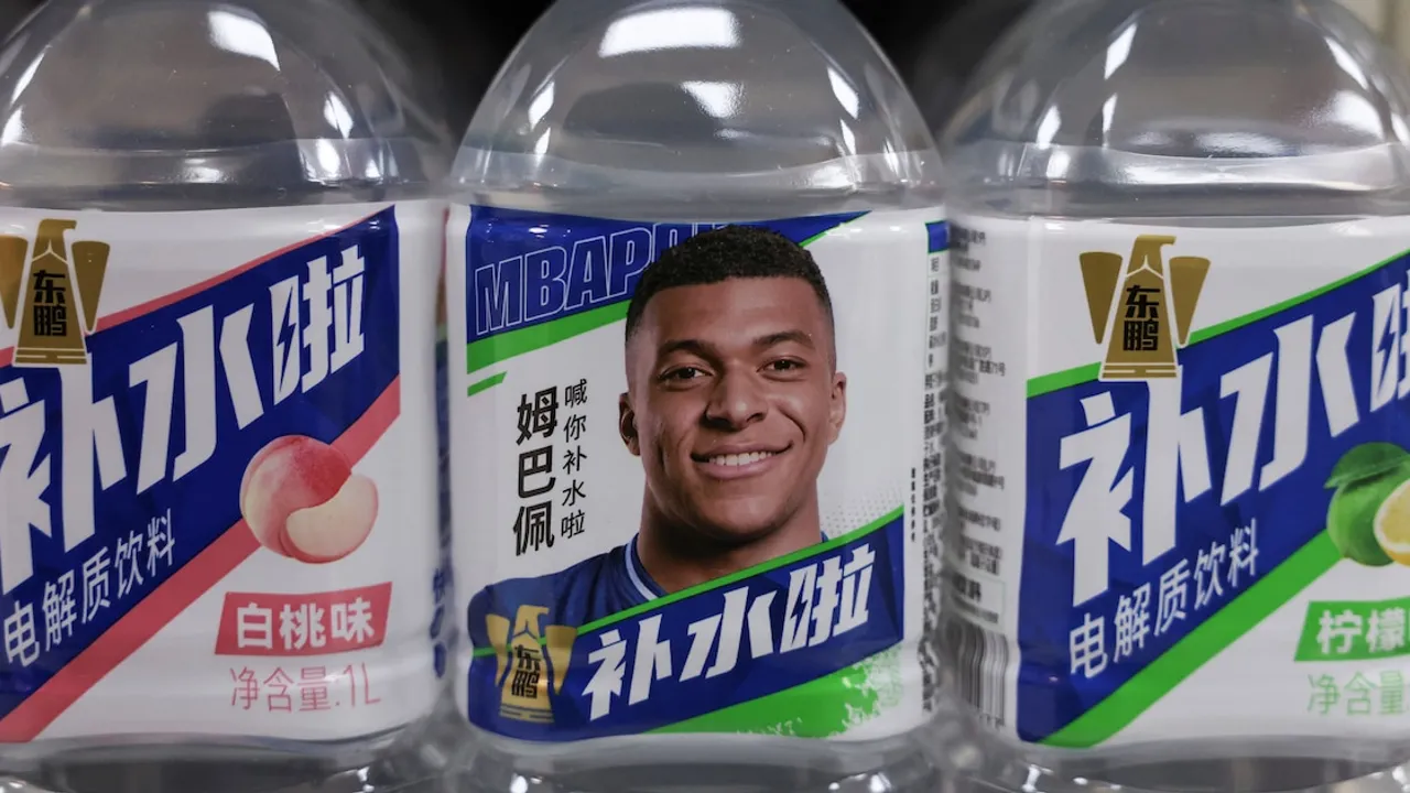 Botellas de bebidas energéticas exhiben el rostro de Kylian Mbappé en el estante de una tienda en Pekín.