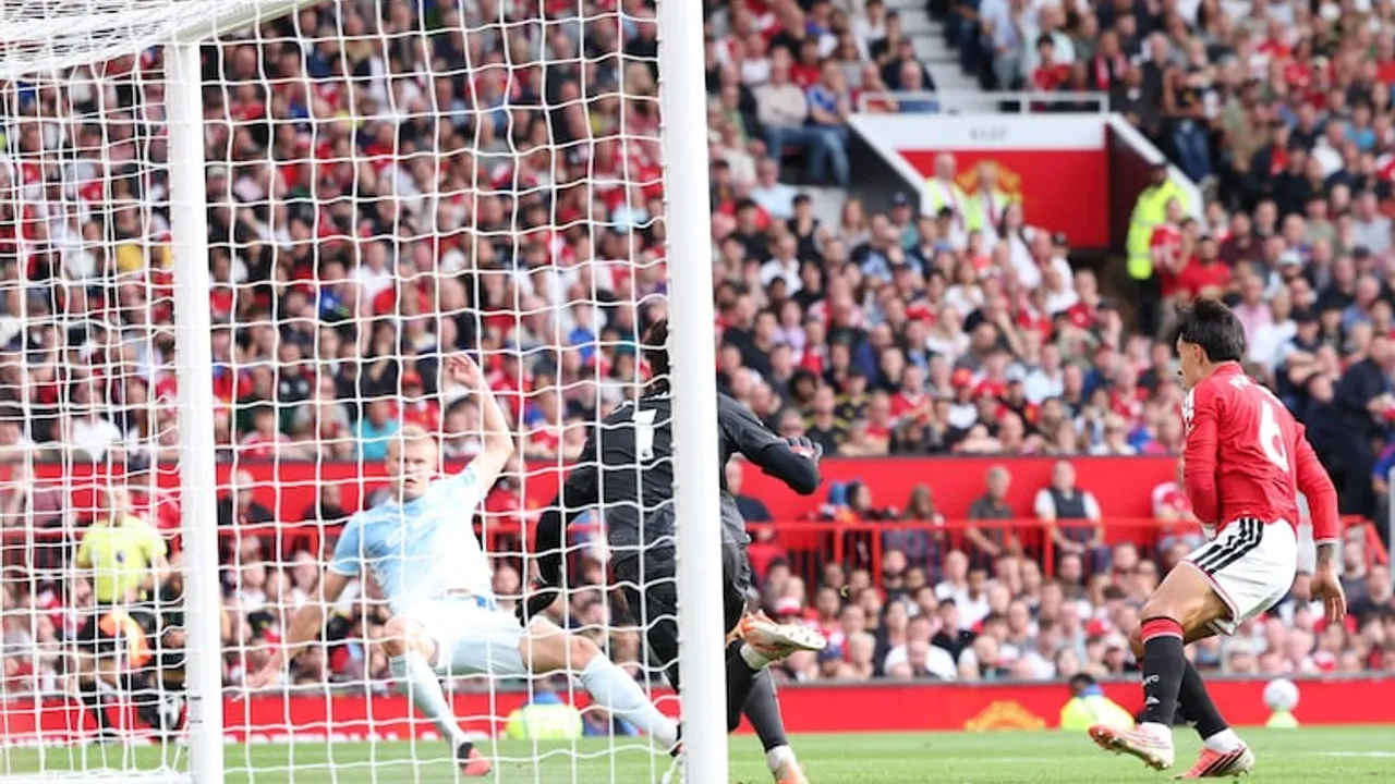 Jugador remata al arco defendido por el Manchester City frente a la red y el público en las gradas.