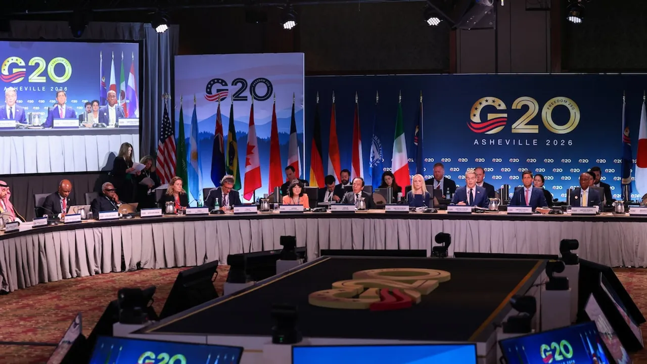 Delegados internacionales dialogan frente a banderas de países en una conferencia plenaria del G20.