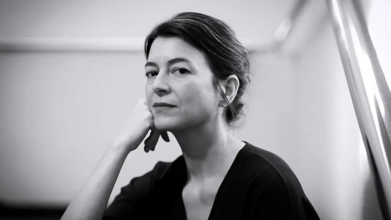 Retrato en blanco y negro de la escritora Samanta Schweblin con la mirada seria y la mano bajo la barbilla