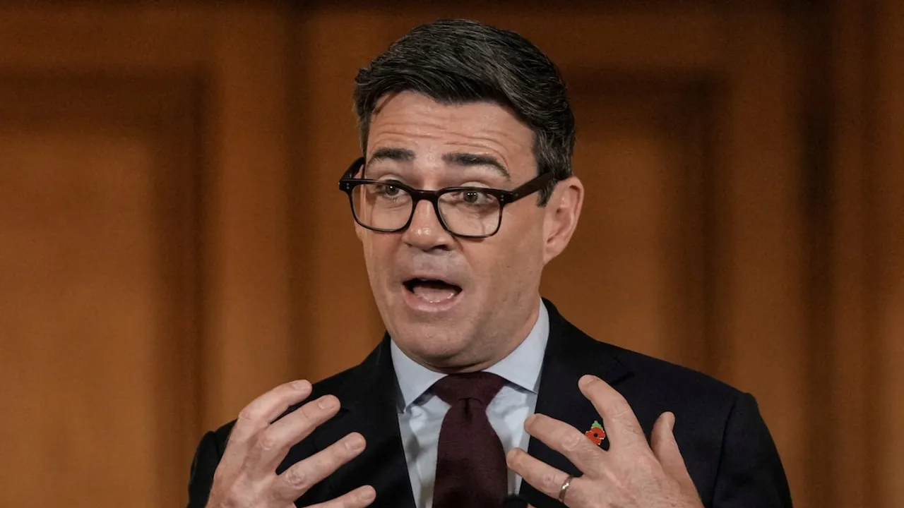 Hombre con gafas oscuras y traje formal gesticulando con ambas manos durante una conferencia de prensa oficial.