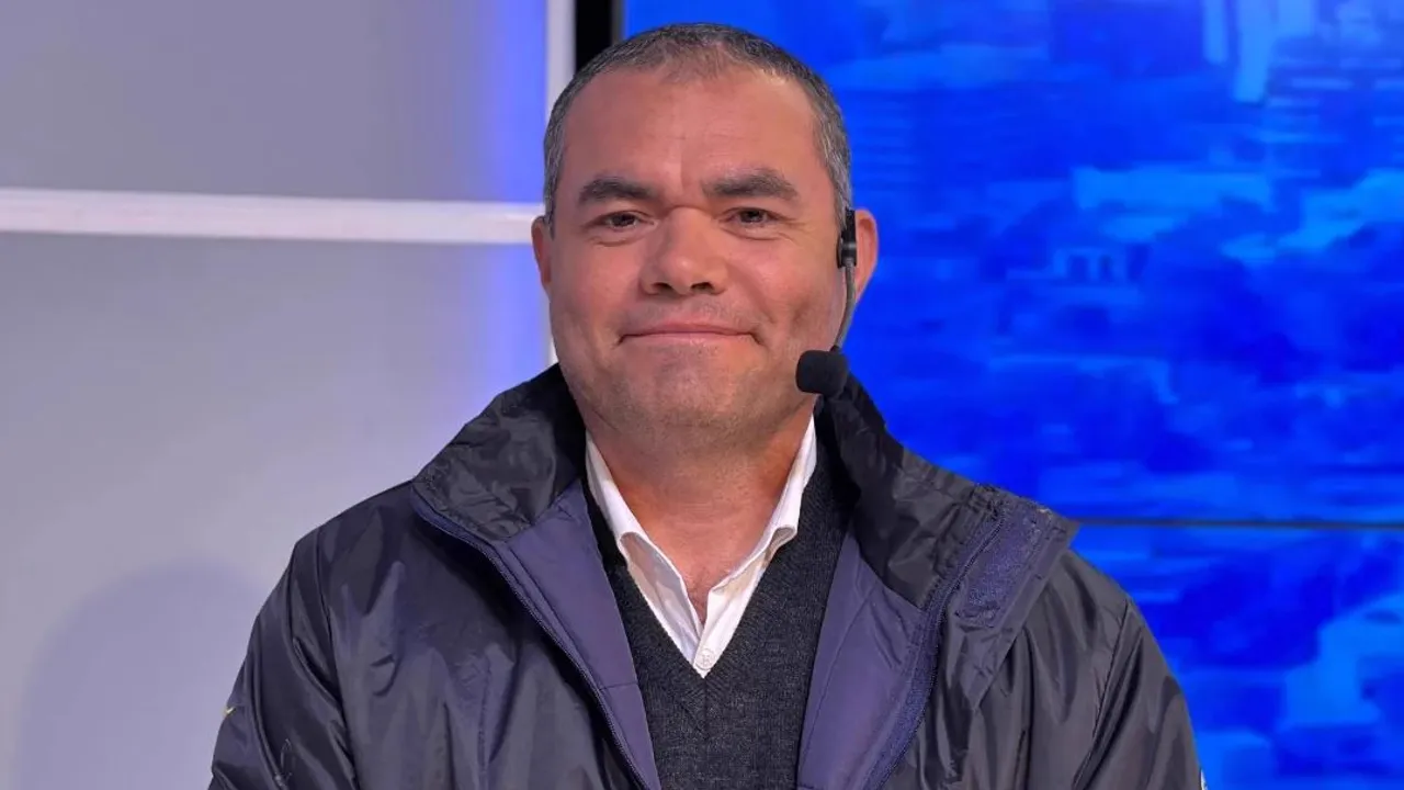 Eduardo Mingo en un estudio televisivo con campera oscura, camisa blanca y micrófono de diadema.