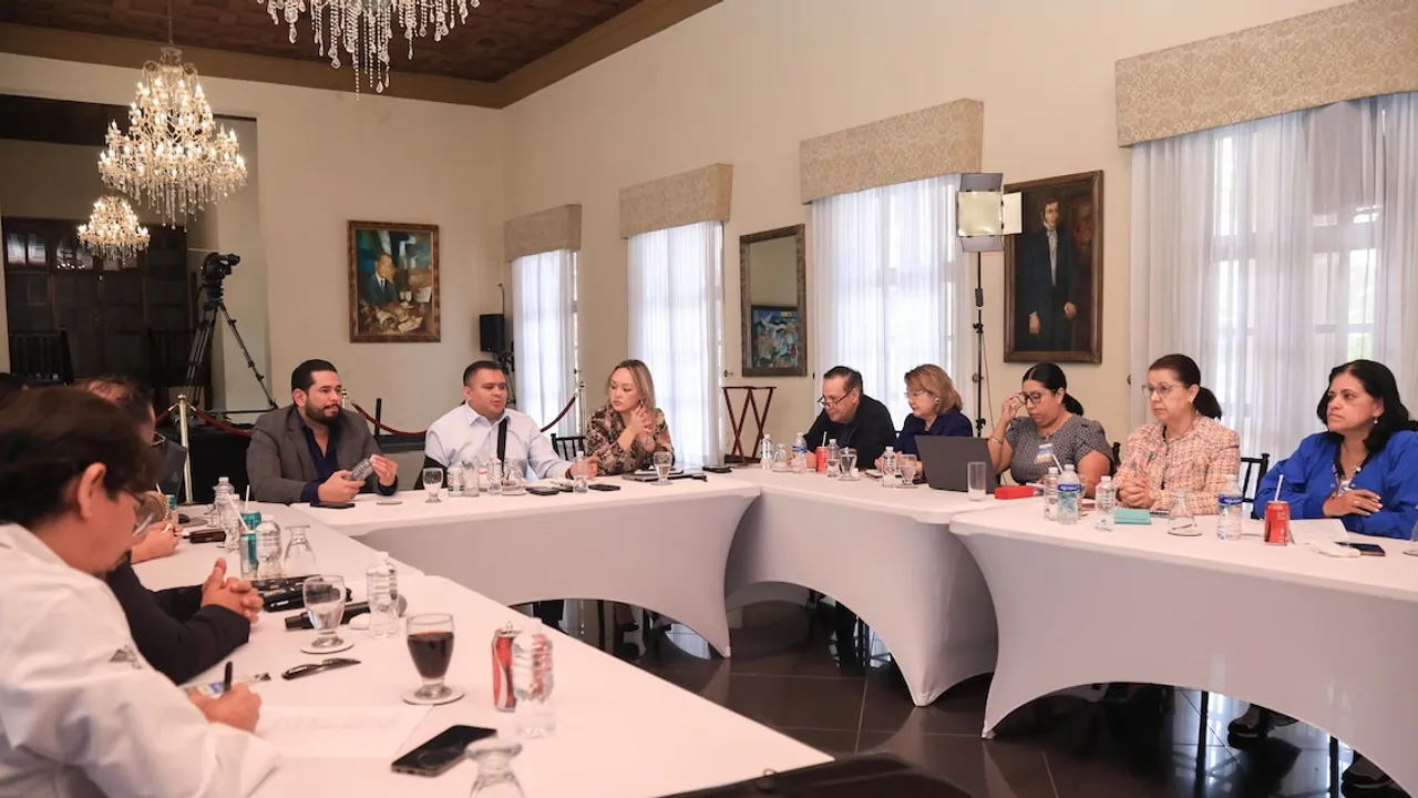 Representantes gubernamentales y gremiales reunidos en una mesa de diálogo en un salón institucional.