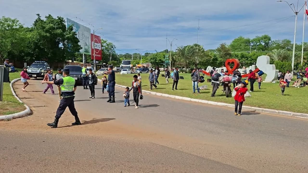 Policías ordenan el tránsito mientras familias indígenas permanecen en la rotonda con monumento en Coronel Oviedo.