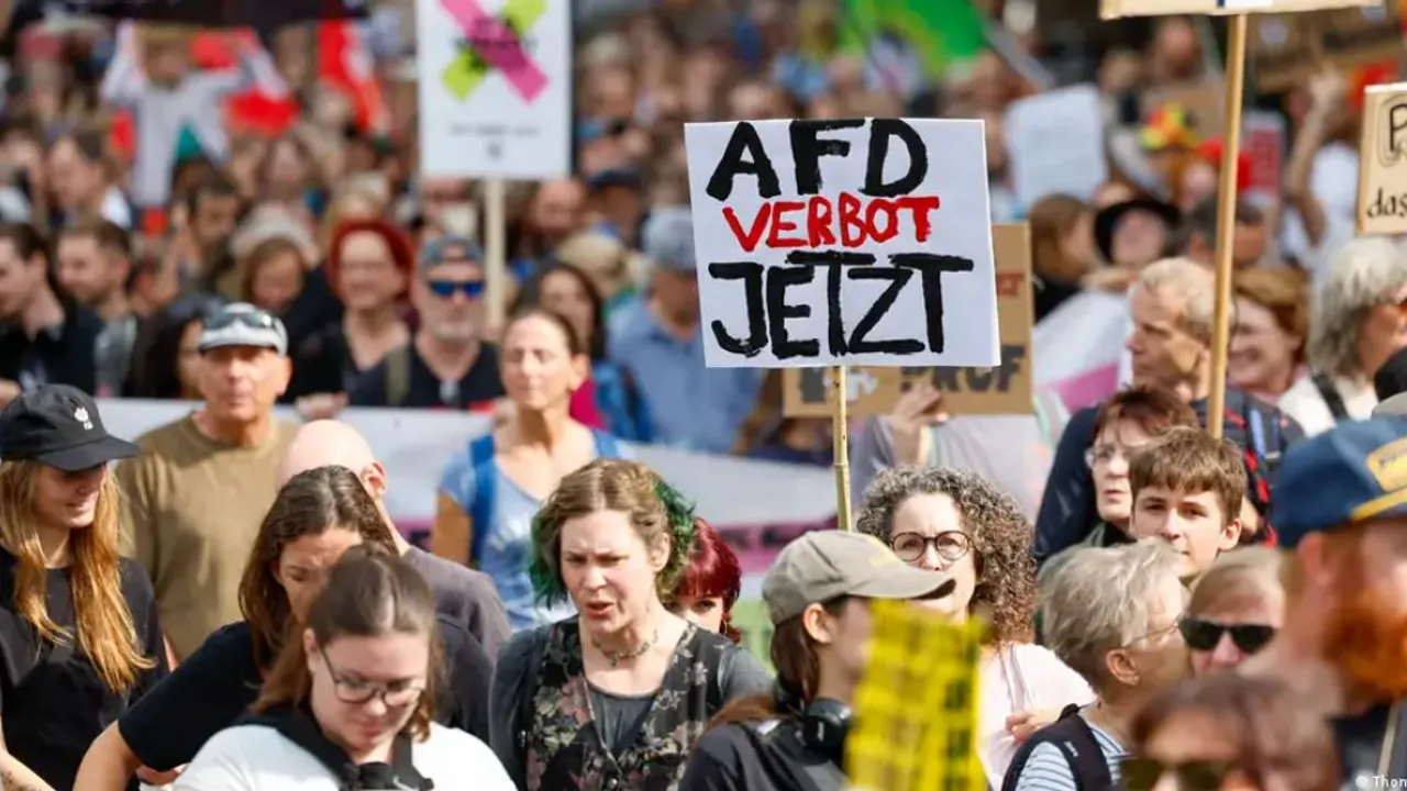 Manifestantes marchan sosteniendo un cartel blanco con la inscripción en alemán AfD Verbot Jetzt.