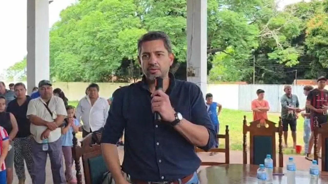 Pedro Alliana con micrófono en mano hablando frente a varias personas reunidas en un patio abierto