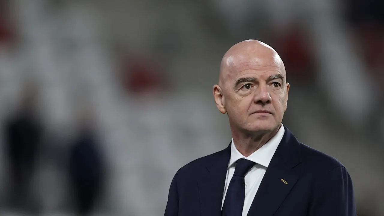 Gianni Infantino, presidente de la FIFA, con traje oscuro y corbata sobre un fondo desenfocado de estadio deportivo.