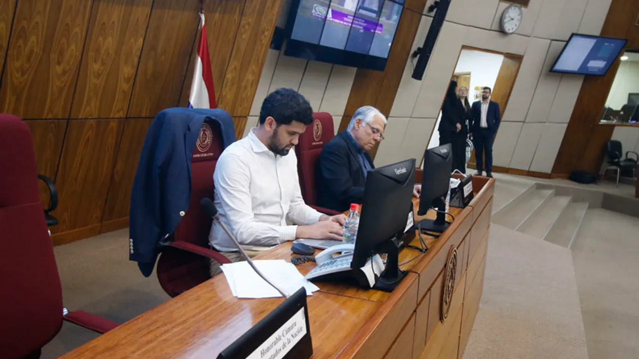 Legisladores y participantes sentados en el estrado de la sala de sesiones de la Cámara de Diputados.