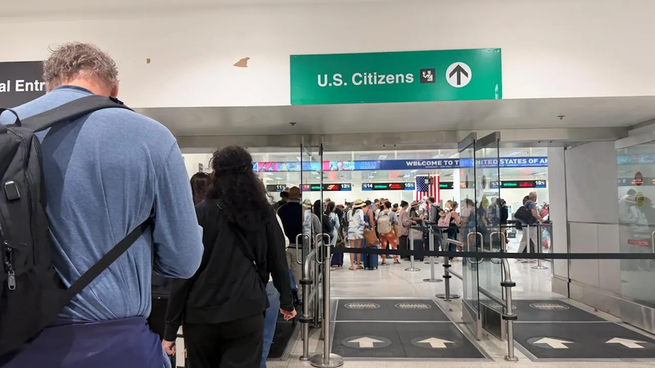 Pasajeros hacen fila frente al área de control migratorio bajo un cartel verde que dice U.S. Citizens en un aeropuerto.