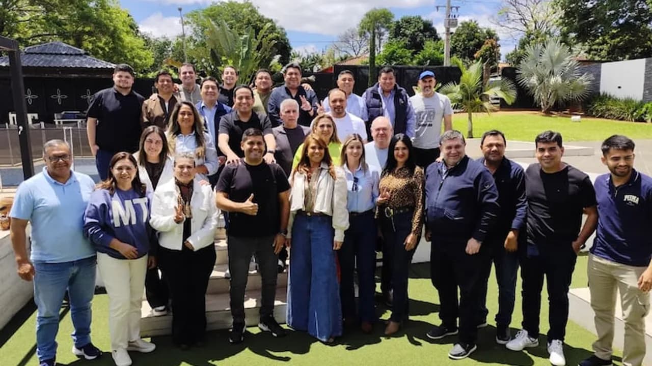 Grupo de dirigentes políticos y referentes partidarios posan sonrientes en un jardín durante un encuentro en Central.