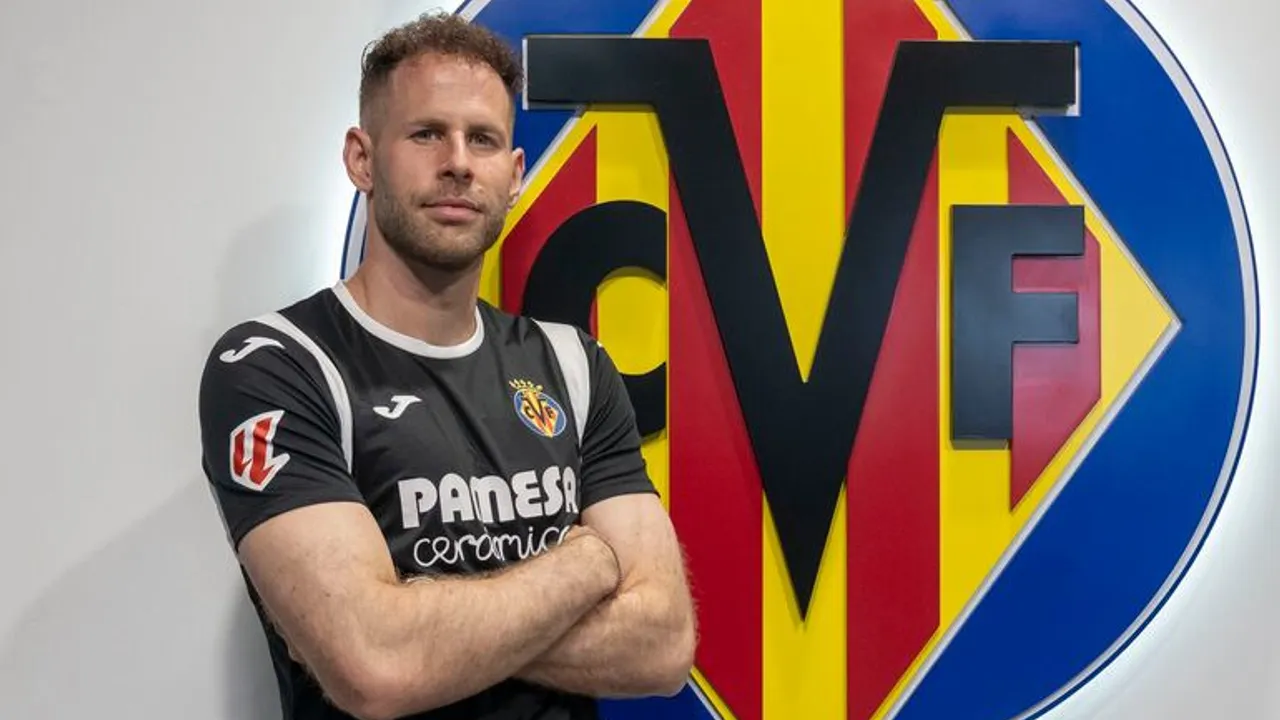 El arquero Peter Gulacsi posa de brazos cruzados con la camiseta del Villarreal frente al escudo del club español.
