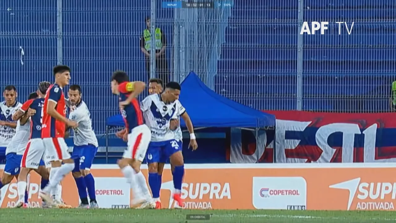 Jugadores de Cerro Porteño y Sportivo Ameliano forcejean durante una disputa cerca de la línea lateral