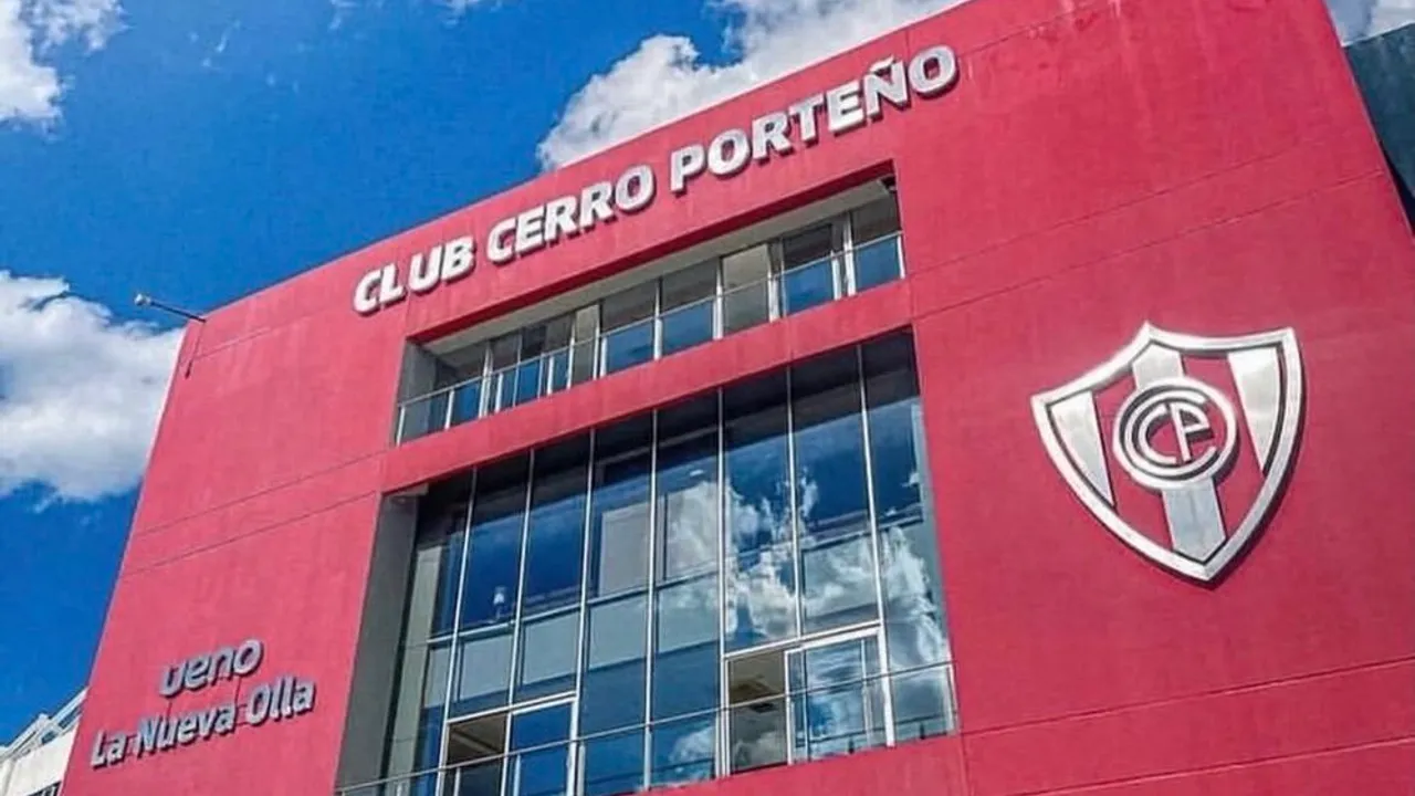 Fachada roja del edificio administrativo del Club Cerro Porteño con su escudo oficial y ventanales.