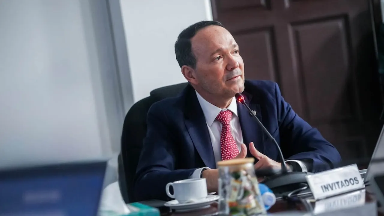 Gustavo Villatoro, ministro salvadoreño, habla ante un micrófono durante una sesión legislativa sobre el presupuesto.