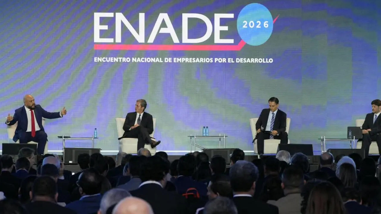 Cuatro disertantes en traje debaten en un escenario frente a una pantalla con el lema del encuentro empresarial.