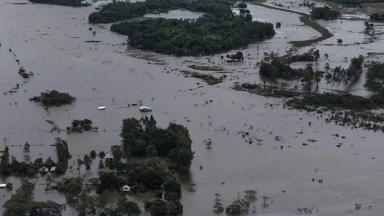 Vista aérea de amplios campos anegados e inundados, con copas de árboles y construcciones rodeadas por las aguas.