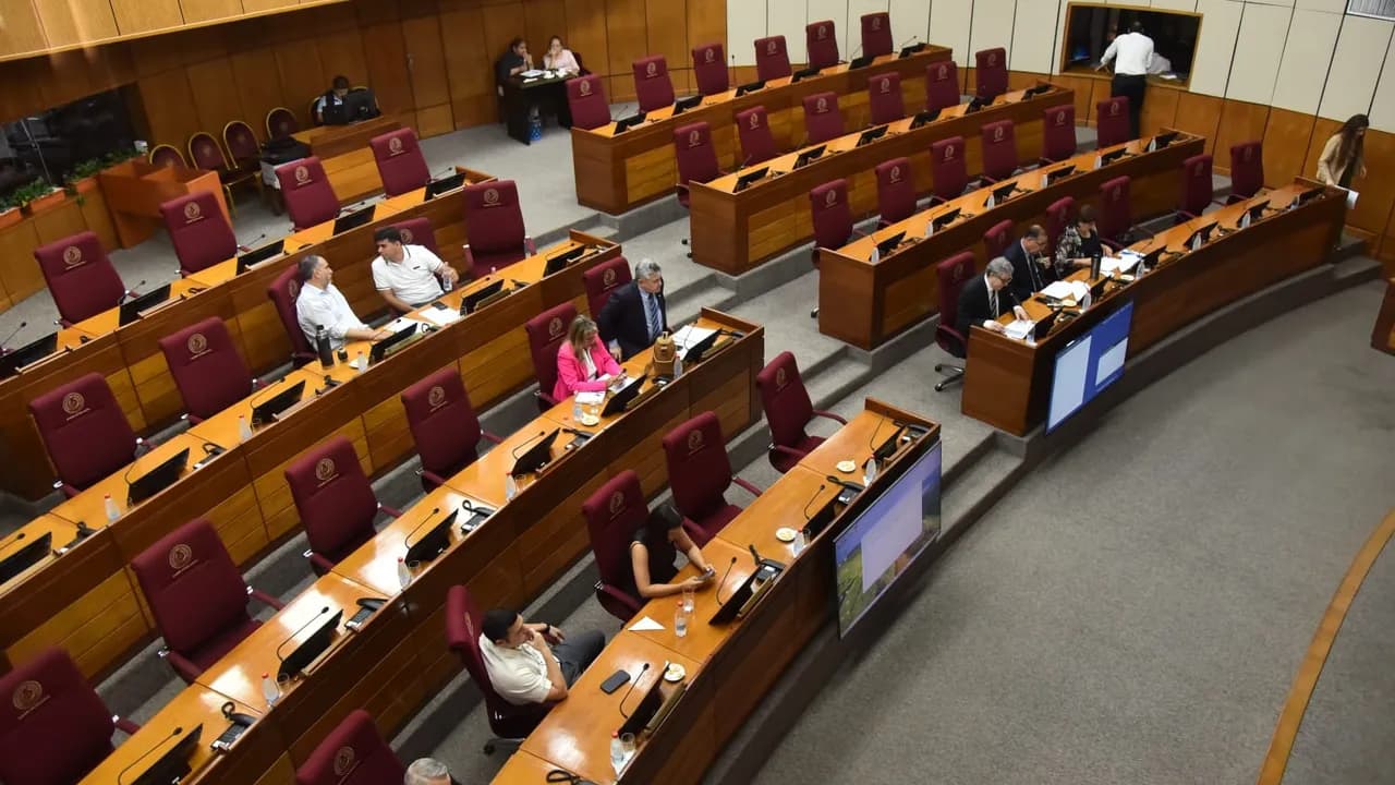 Vista panorámica de la sala de sesiones del Congreso con bancas de madera y escasa presencia de legisladores.