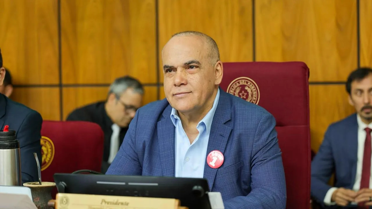 Basilio Núñez viste traje azul y camisa clara sentado en su lugar de presidente en la sala del Senado.