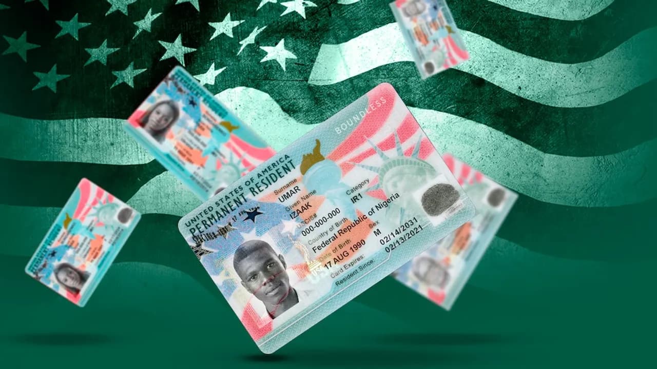 Tarjetas de residencia permanente de Estados Unidos flotando sobre un fondo con la bandera nacional norteamericana.