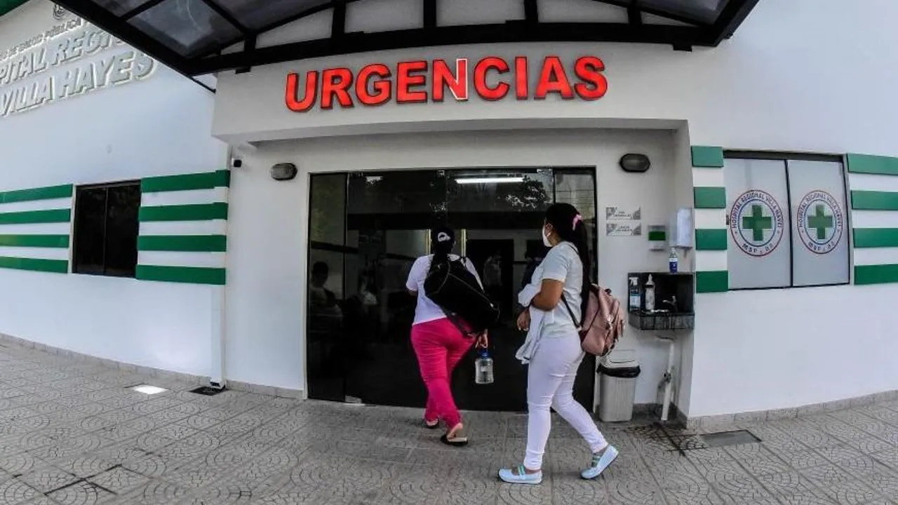 Fachada y puerta de Urgencias del Hospital de Villa Hayes con dos personas con bolsos al ingresar