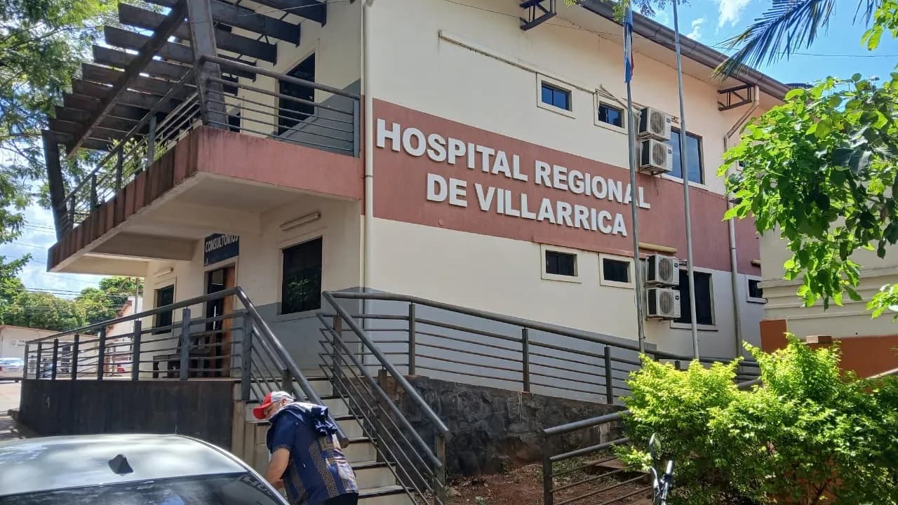 Fachada del Hospital Regional de Villarrica con rampa de acceso y cartelería visible bajo el sol.
