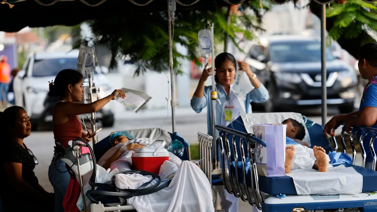 Pacientes en camillas reciben suero y atención médica bajo un toldo instalado en el exterior de un hospital.